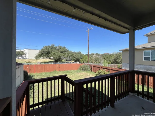 a view of a balcony with wooden floor & fence