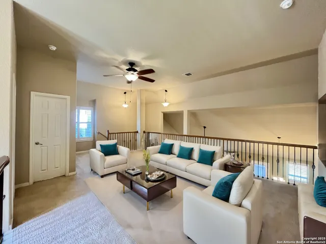 a living room with furniture ceiling fan and a rug