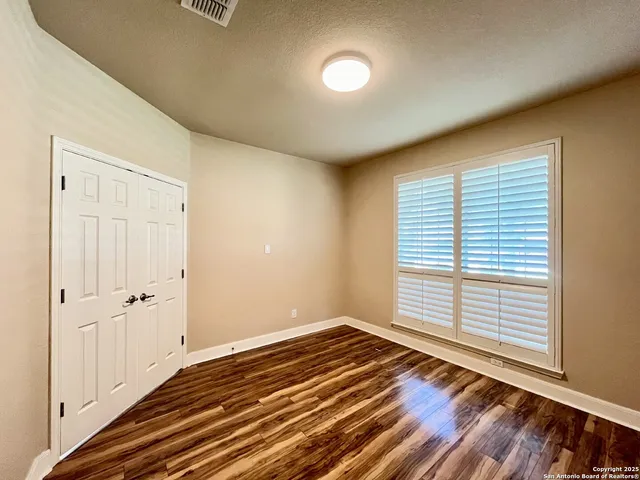a view of a room with wooden floor and window