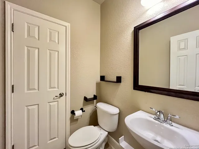 a bathroom with a toilet a sink and mirror