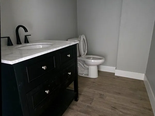 a bathroom with a toilet sink and mirror