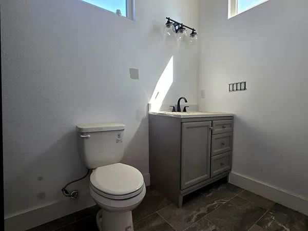 a bathroom with a toilet sink and vanity
