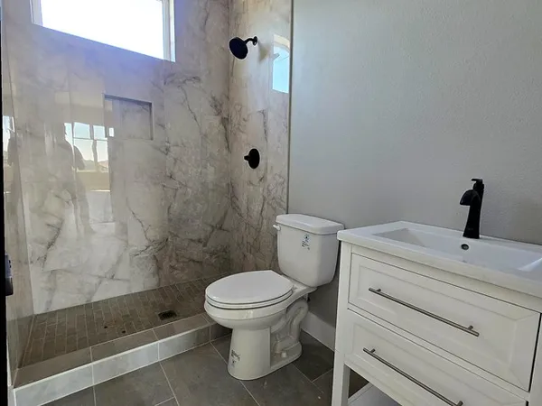 a bathroom with a shower a toilet and a sink
