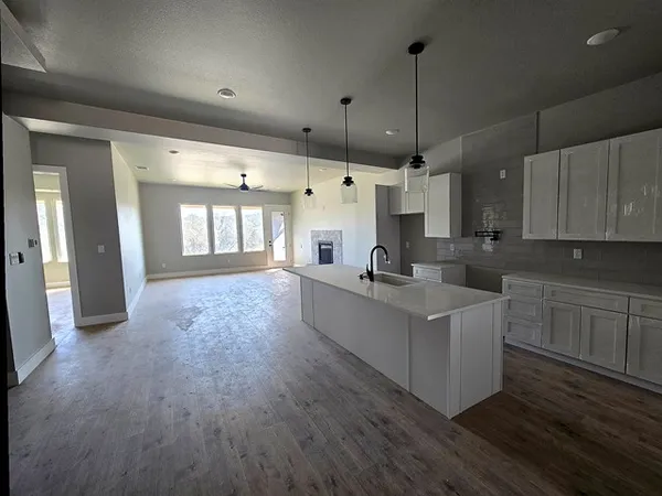 a large white kitchen with wooden floors and white walls