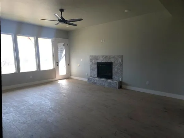 a view of an empty room with a fireplace and a window