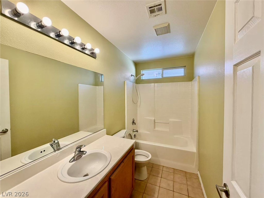7326 Dicentra Road Las Vegas, NV 89113 - Photo 13 of 18 A classic bathroom layout includes a vanity setup and built-in tub with tile flooring.