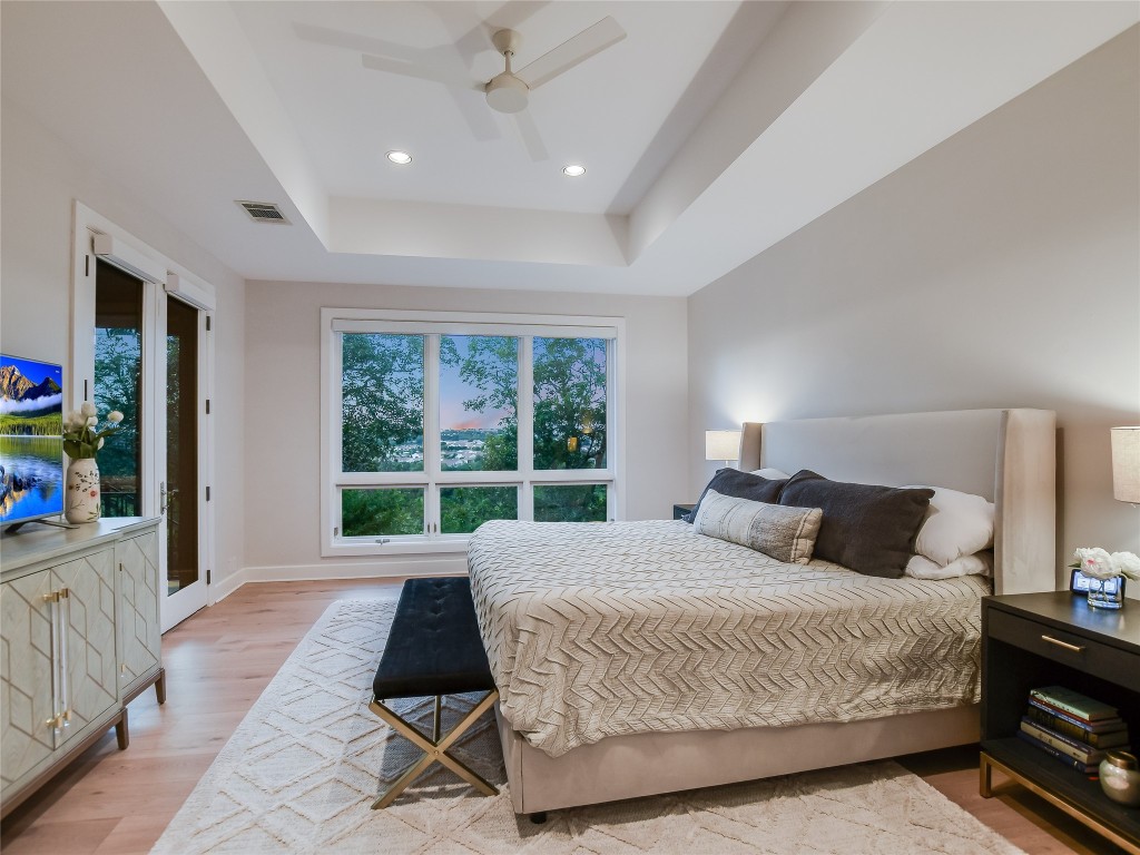 4704 Monte Carmelo Place Austin, TX 78738 - Photo 17 of 30 a bedroom with a bed lamp and a large window