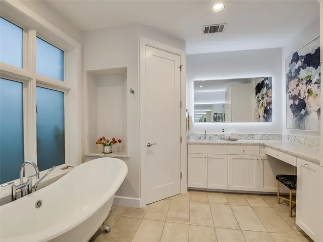 a bathroom with a tub sink and mirror