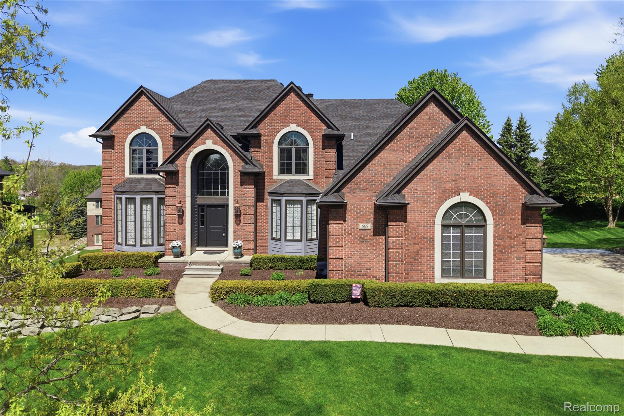 668 Springview Drive Rochester, MI 48307 - Photo 1 of 90 Traditional-style house with a front lawn and brick siding