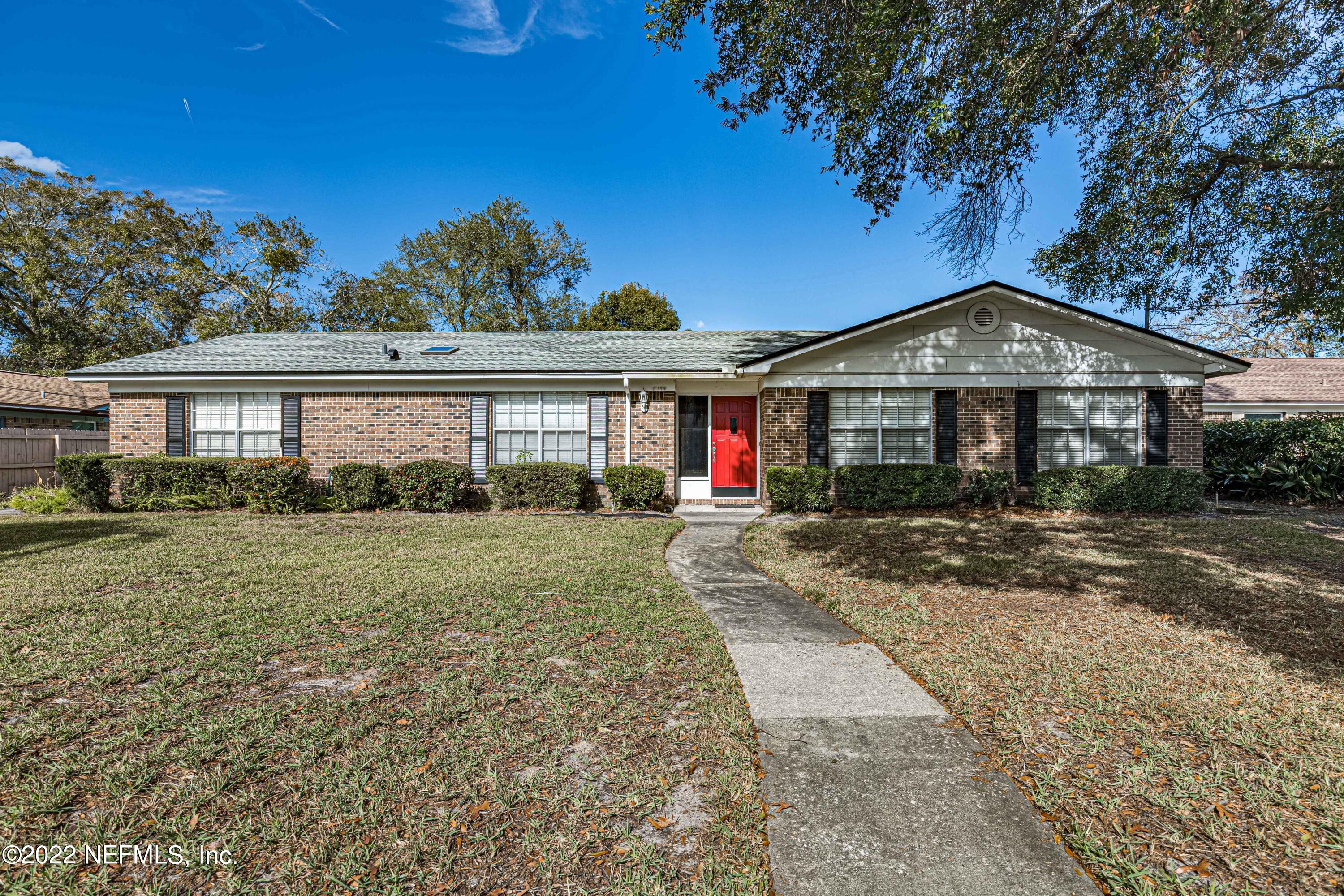 7339 Sandy Bluff Drive Jacksonville, FL 32277 - Photo 1 of 35 a front view of a house with a yard and road