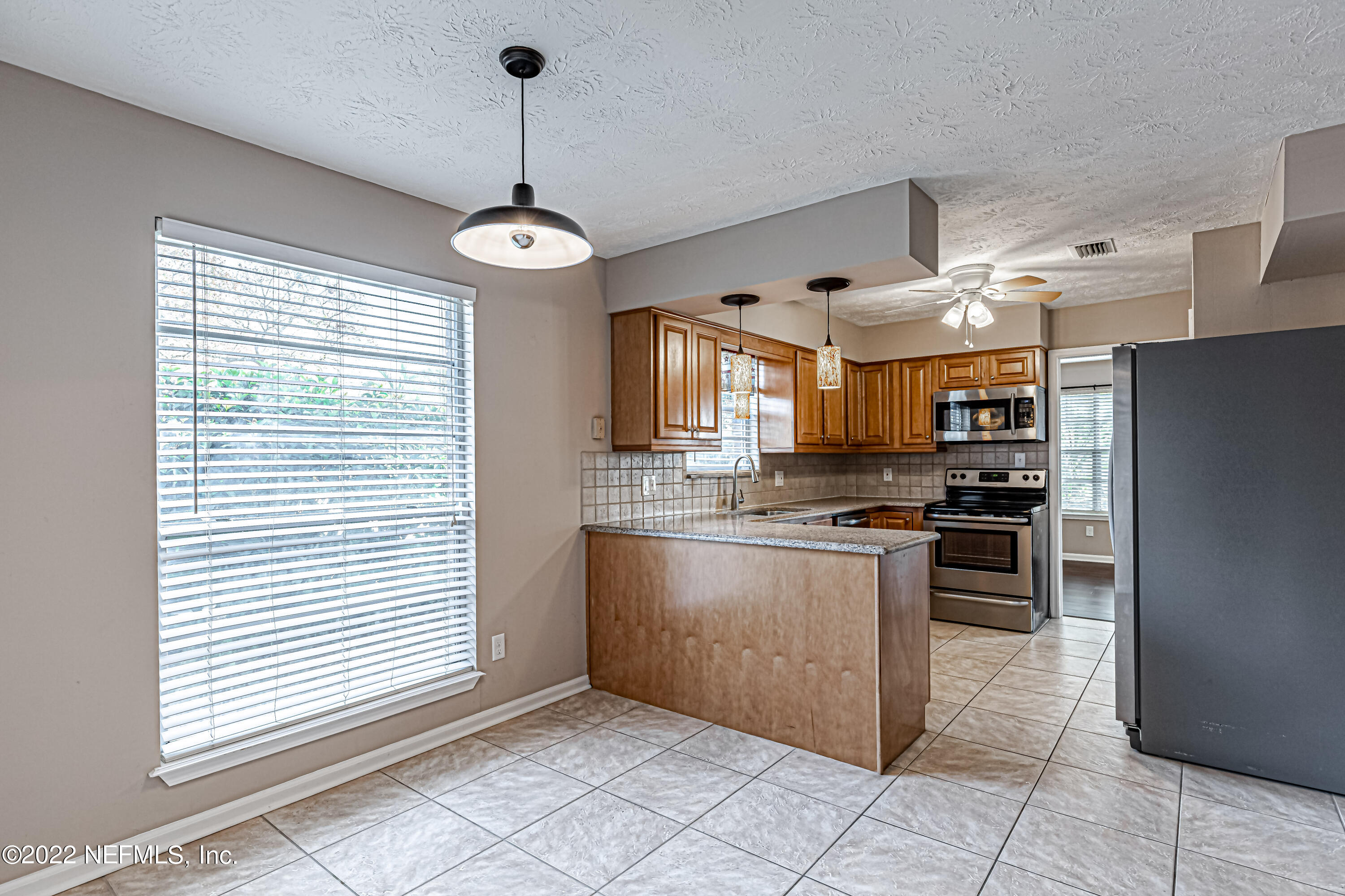 7339 Sandy Bluff Drive Jacksonville, FL 32277 - Photo 17 of 35 a kitchen with stainless steel appliances granite countertop a stove and a refrigerator