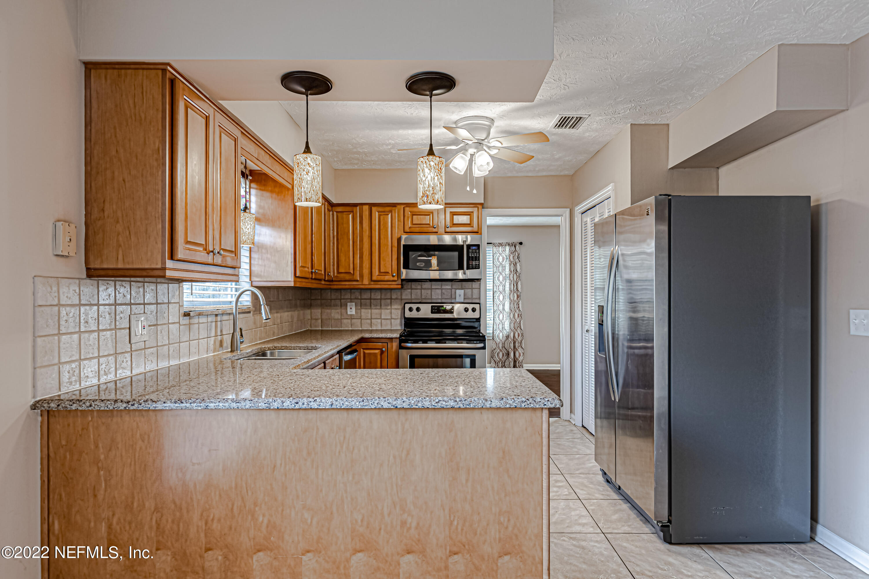 7339 Sandy Bluff Drive Jacksonville, FL 32277 - Photo 18 of 35 a kitchen with stainless steel appliances granite countertop a refrigerator a stove and a sink
