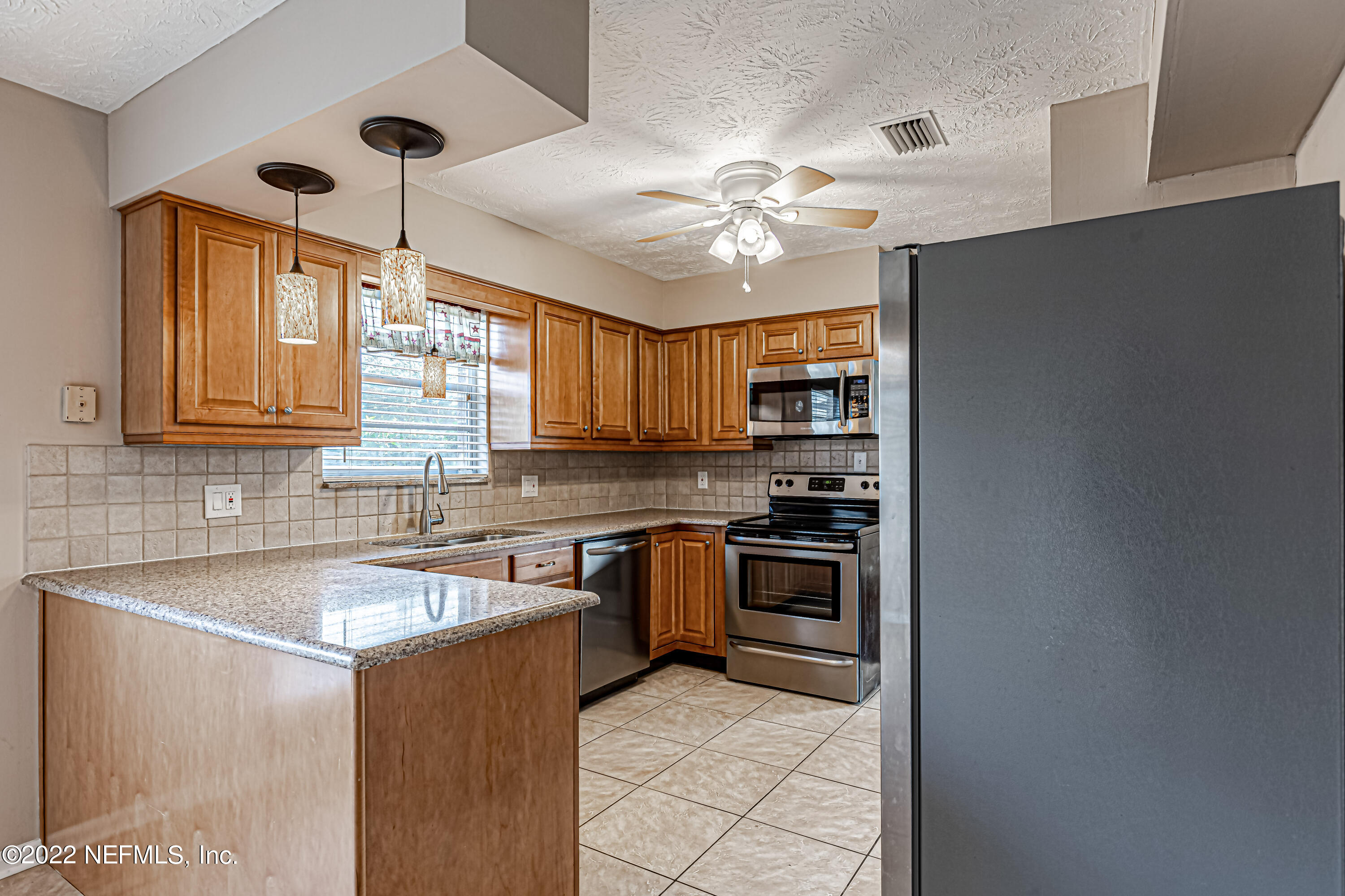7339 Sandy Bluff Drive Jacksonville, FL 32277 - Photo 19 of 35 a kitchen with stainless steel appliances granite countertop a sink a stove and a refrigerator