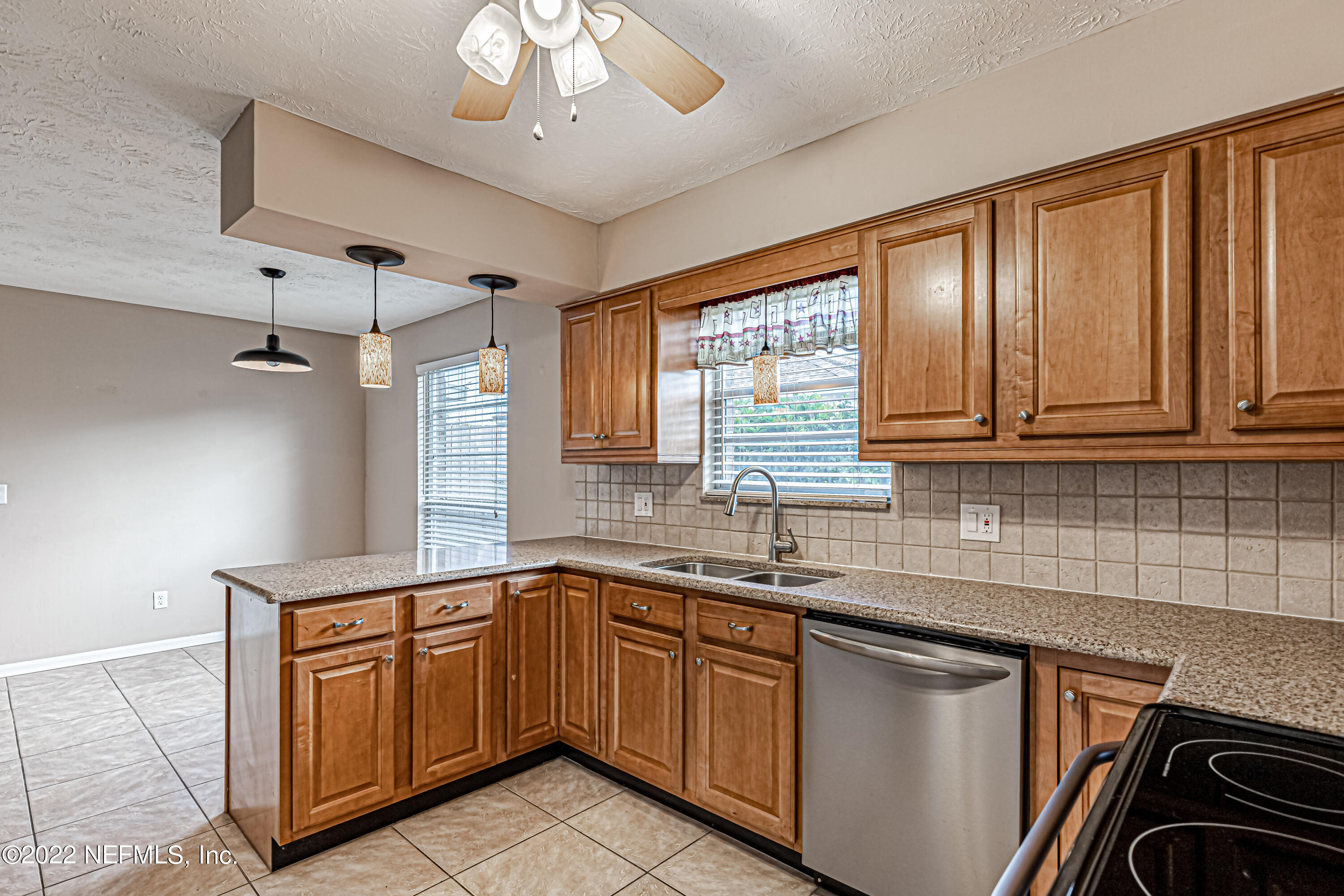 7339 Sandy Bluff Drive Jacksonville, FL 32277 - Photo 20 of 35 a kitchen with kitchen island granite countertop a sink stainless steel appliances cabinets and a counter top space