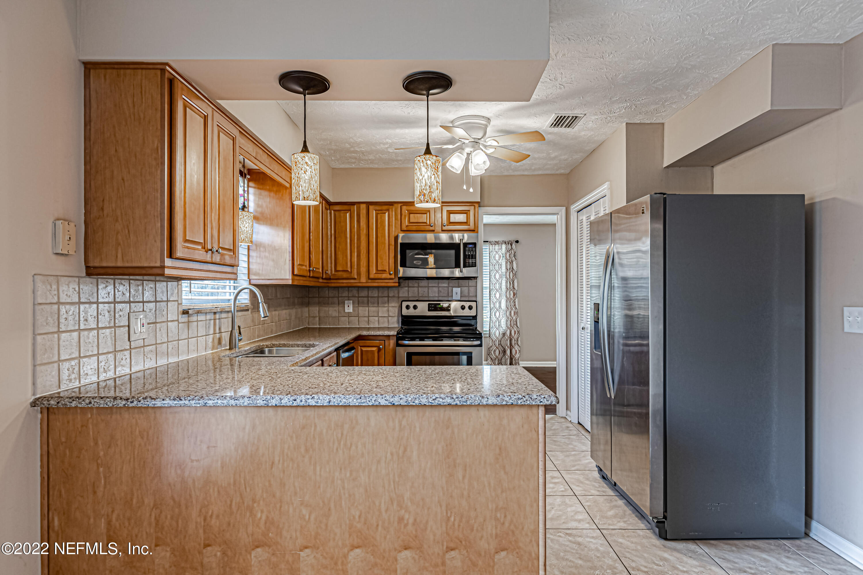 7339 Sandy Bluff Drive Jacksonville, FL 32277 - Photo 21 of 35 a kitchen with stainless steel appliances granite countertop a refrigerator a stove and a sink