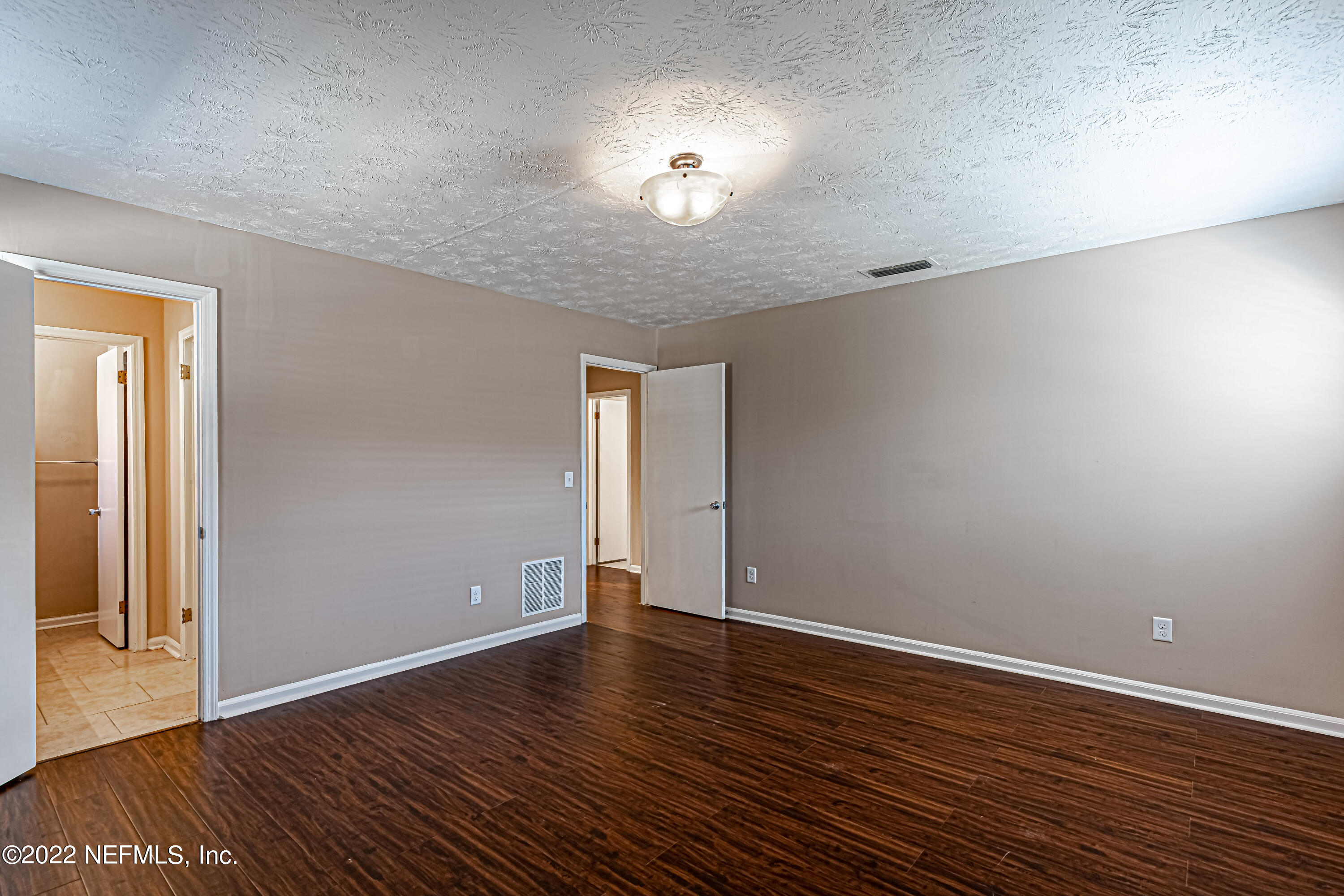 7339 Sandy Bluff Drive Jacksonville, FL 32277 - Photo 22 of 35 a view of an empty room with wooden floor and a window