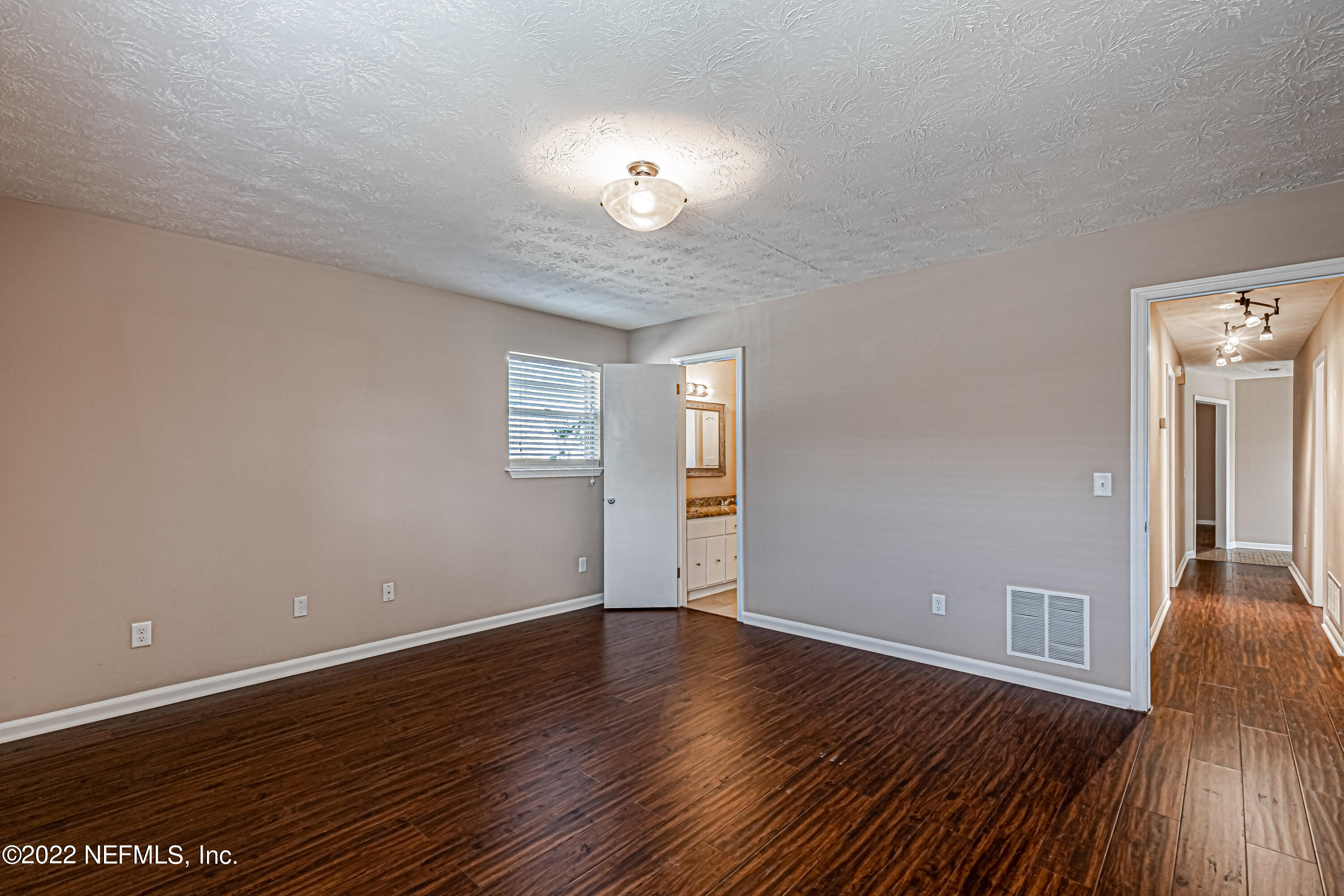 7339 Sandy Bluff Drive Jacksonville, FL 32277 - Photo 23 of 35 a view of an empty room with wooden floor and a window
