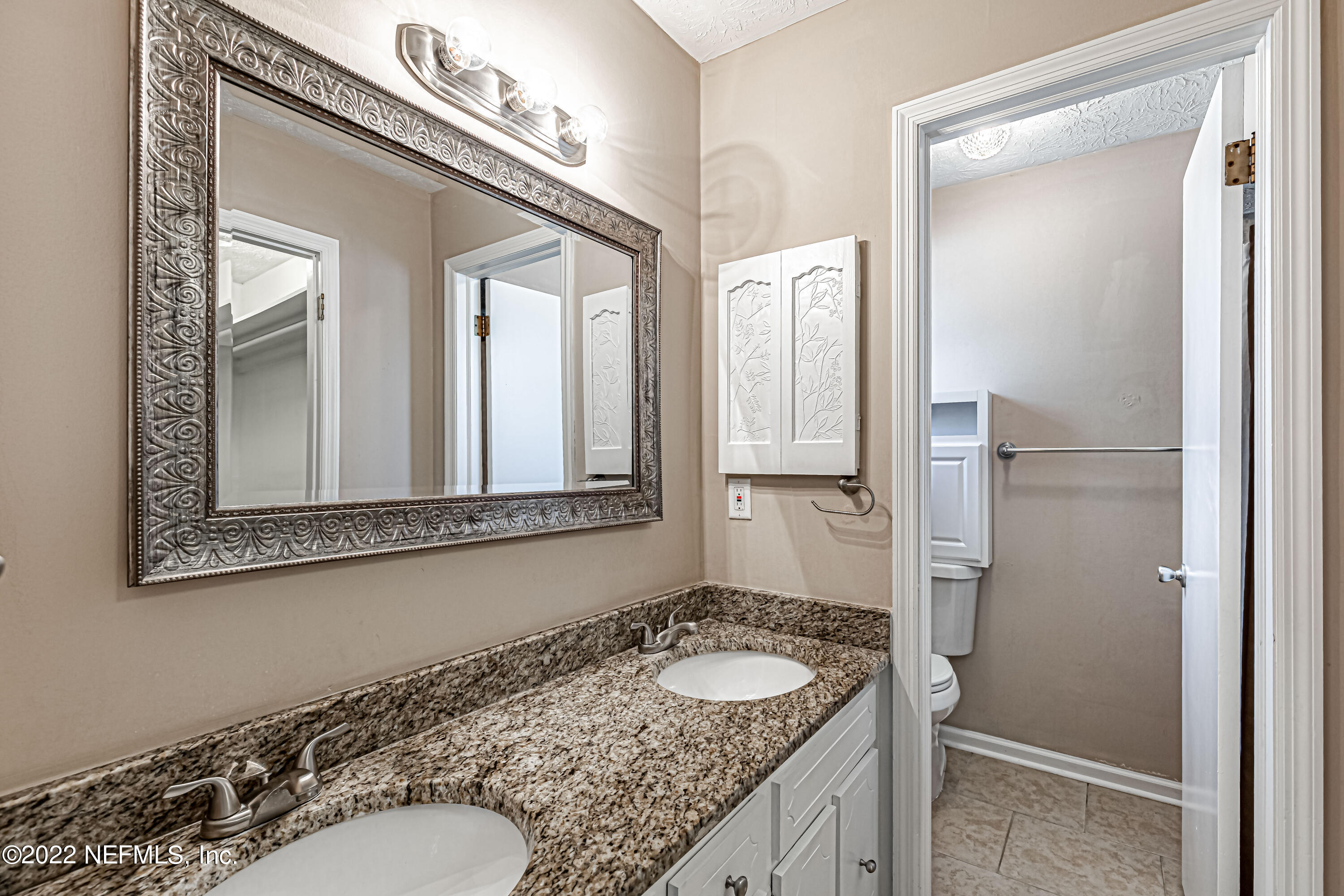 7339 Sandy Bluff Drive Jacksonville, FL 32277 - Photo 25 of 35 a bathroom with a granite countertop sink and a mirror