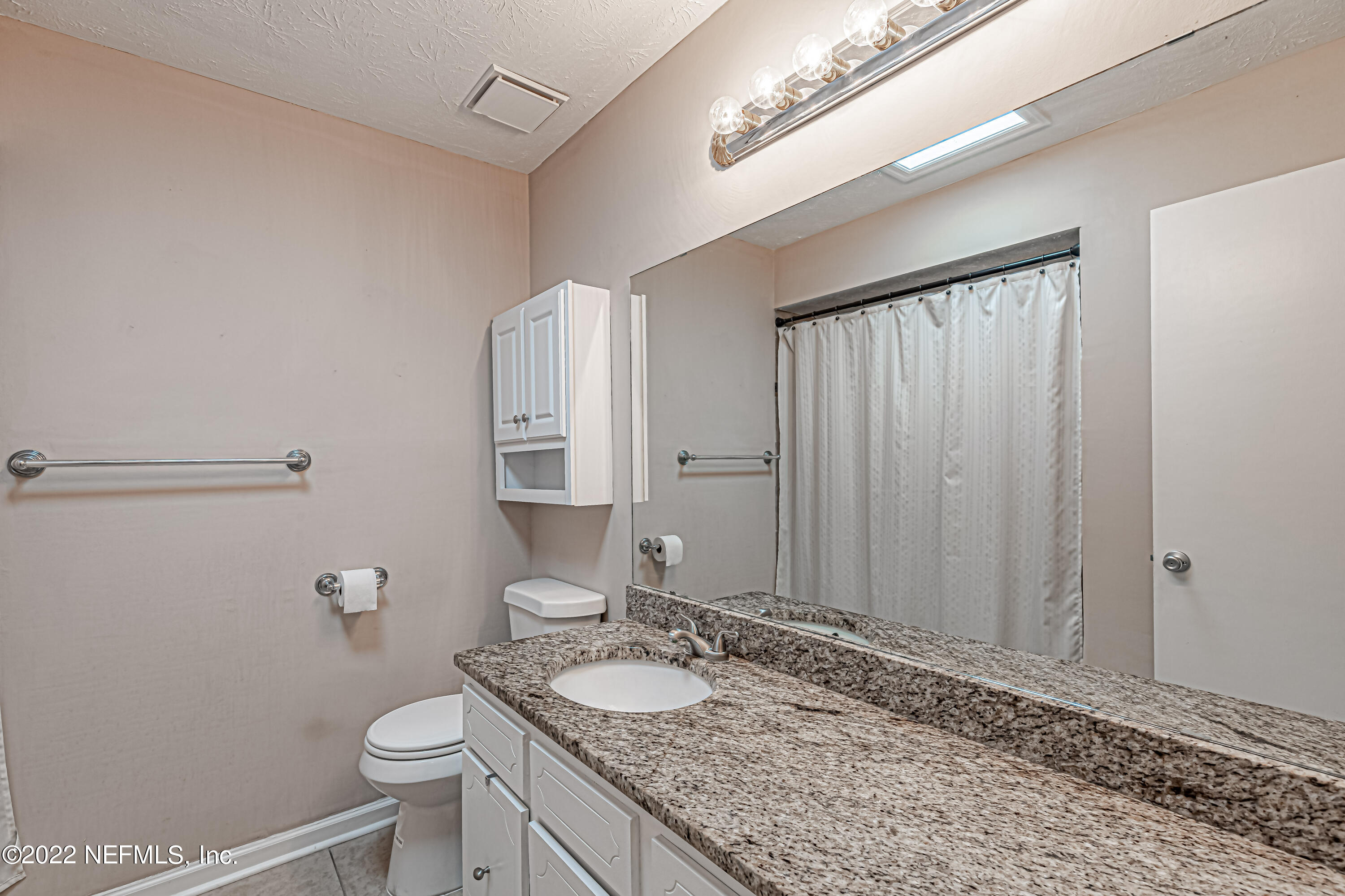 7339 Sandy Bluff Drive Jacksonville, FL 32277 - Photo 29 of 35 a bathroom with a granite countertop sink a toilet and mirror