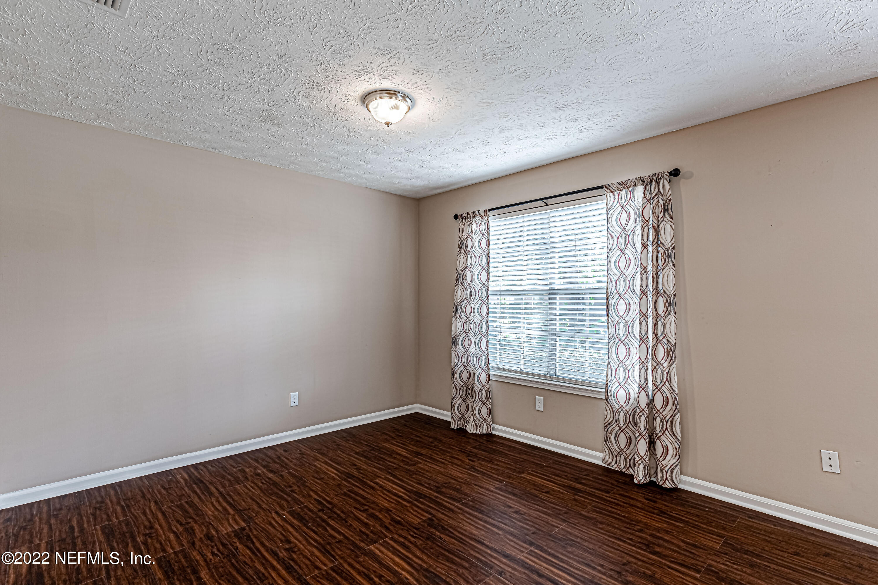 7339 Sandy Bluff Drive Jacksonville, FL 32277 - Photo 9 of 35 a view of an empty room with wooden floor and a window