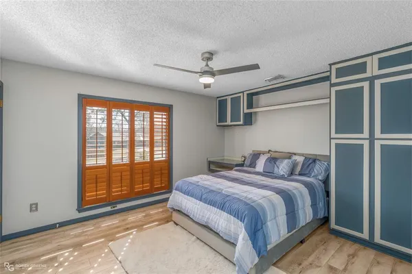 a bedroom with a bed and large windows
