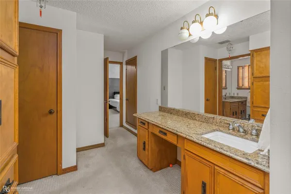 a bathroom with a granite countertop toilet sink and mirror