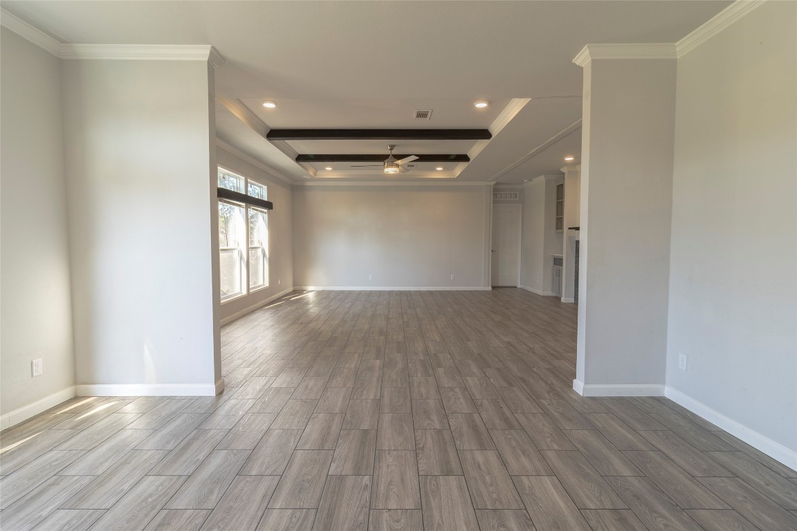 425 High View Ranch Drive Cedar Creek, TX 78612 - Photo 18 of 36 Empty room with a tray ceiling, ornamental molding, wood finish floors, a ceiling fan, and recessed lighting