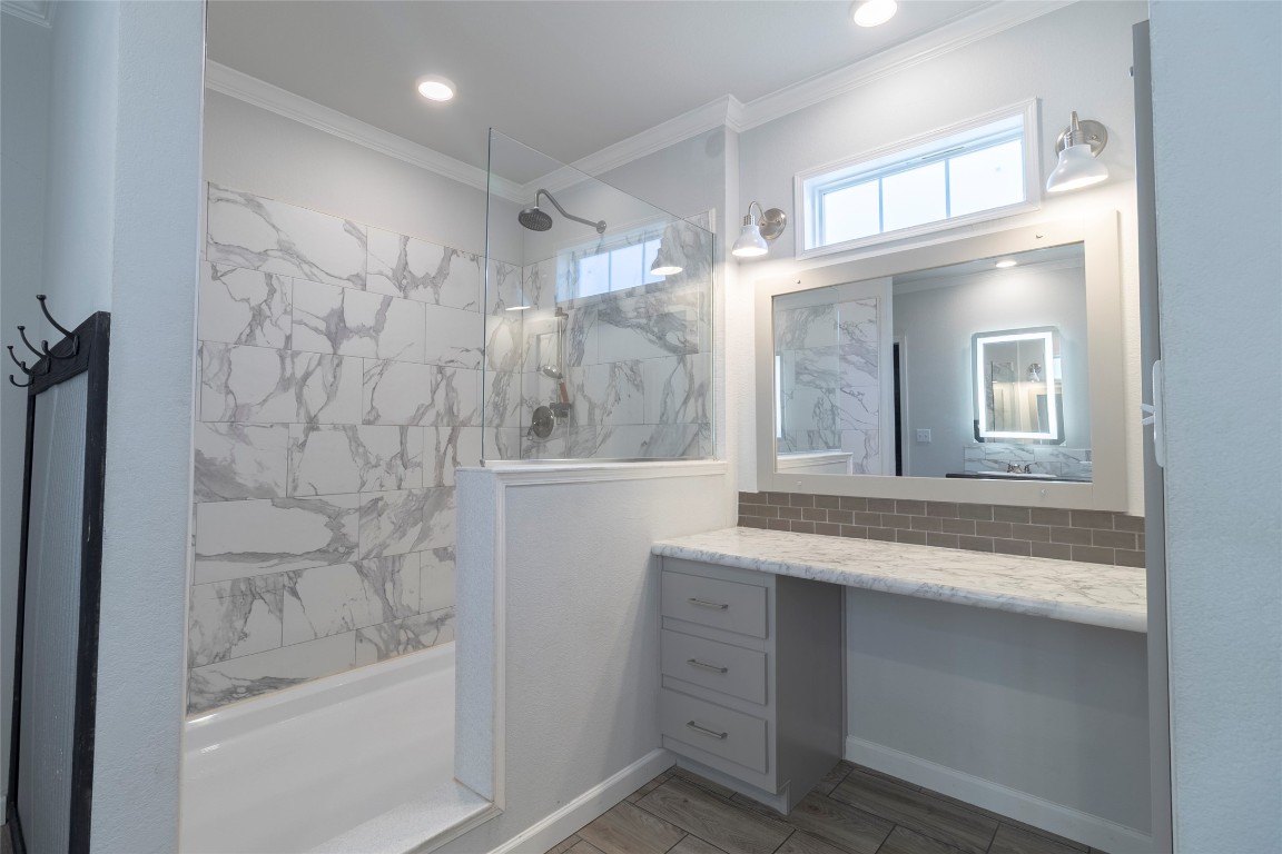 425 High View Ranch Drive Cedar Creek, TX 78612 - Photo 24 of 36 Bathroom featuring ornamental molding, a walk in shower, vanity, backsplash, and wood tiled floors