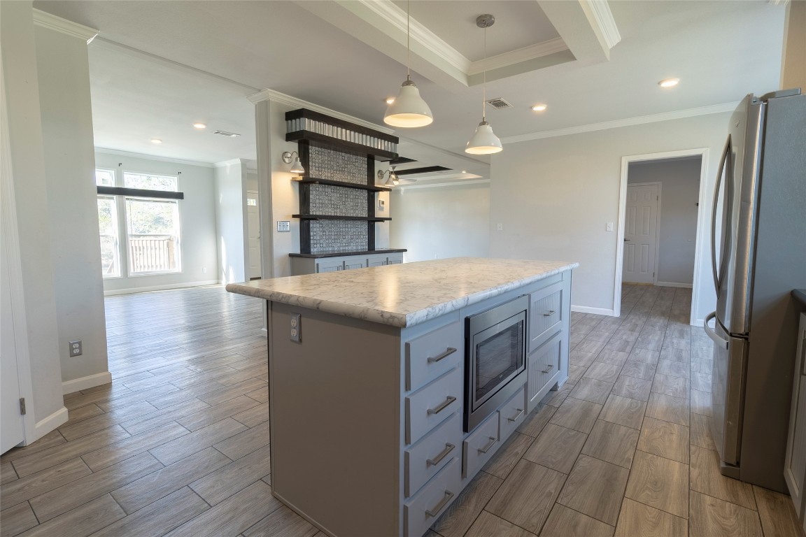 425 High View Ranch Drive Cedar Creek, TX 78612 - Photo 34 of 36 Kitchen with wood finish floors, a kitchen island, appliances with stainless steel finishes, recessed lighting, and pendant lighting