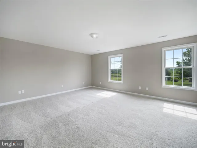 a view of a big room with windows and chandelier fan
