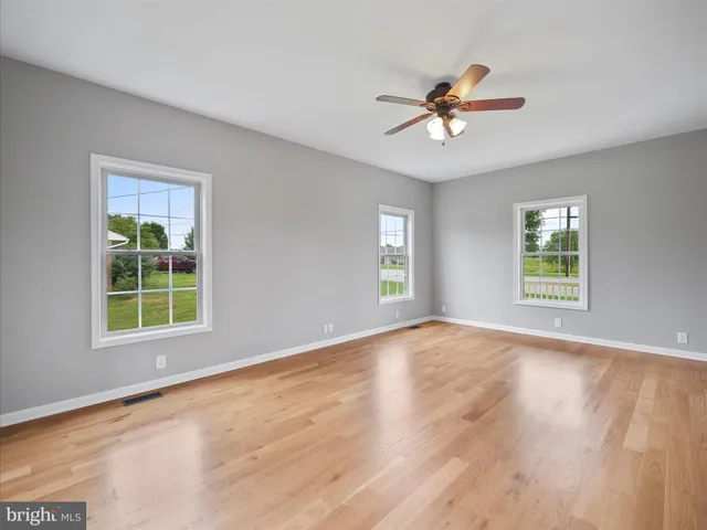an empty room with window and a ceiling fan