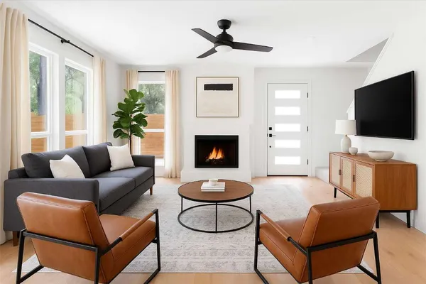 a living room with furniture a flat screen tv and a fireplace