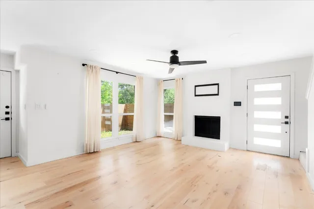 a view of empty room with wooden floor and windows