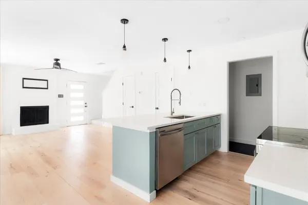 a kitchen with stainless steel appliances granite countertop a sink and a stove with white countertops