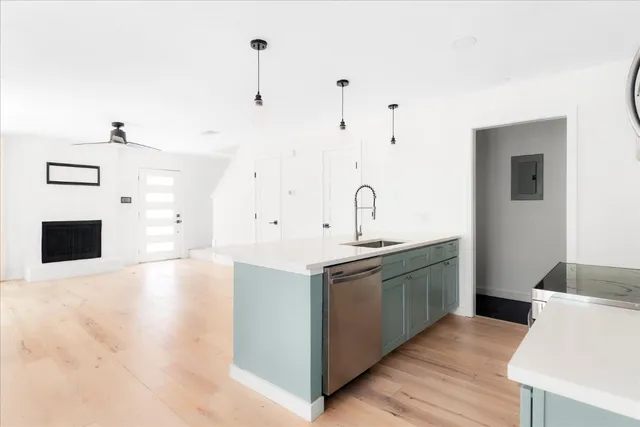 a kitchen with stainless steel appliances granite countertop a sink and a stove with white countertops