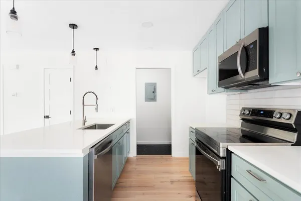 a kitchen with stainless steel appliances a stove microwave and sink