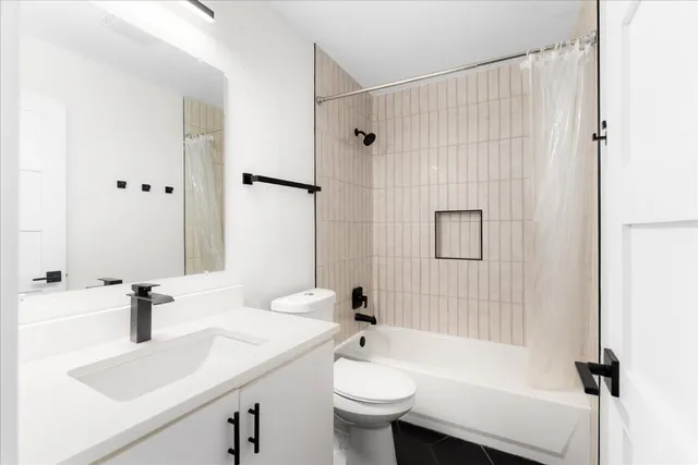 a bathroom with a sink a toilet and shower