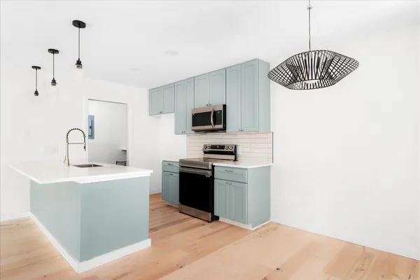 a kitchen with stainless steel appliances granite countertop a sink a stove and a refrigerator