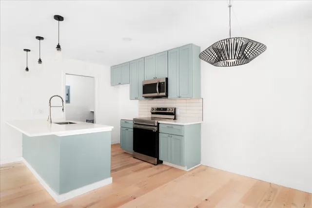 a kitchen with stainless steel appliances granite countertop a sink a stove and a refrigerator