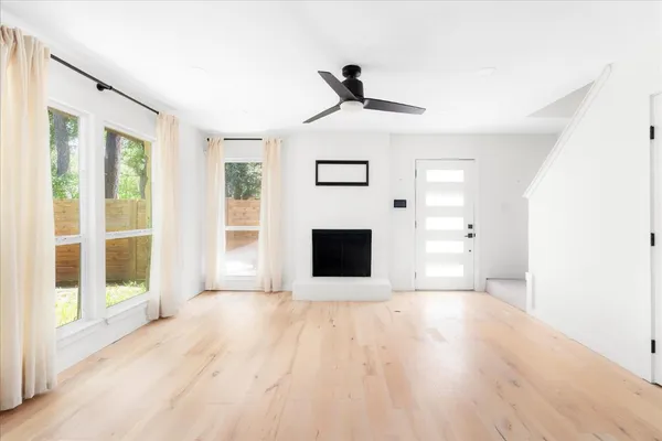 a view of a livingroom with wooden floor and a fireplace