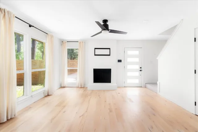 a view of a livingroom with wooden floor and a fireplace