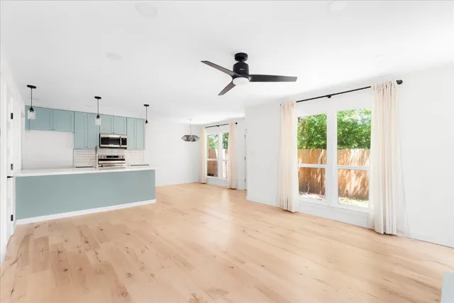 a view of a kitchen with wooden floor and stainless steel appliances