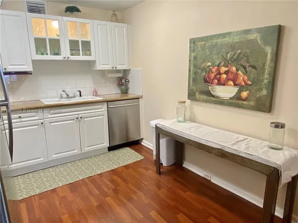 a view of cabinets with wooden floor and electronic appliances