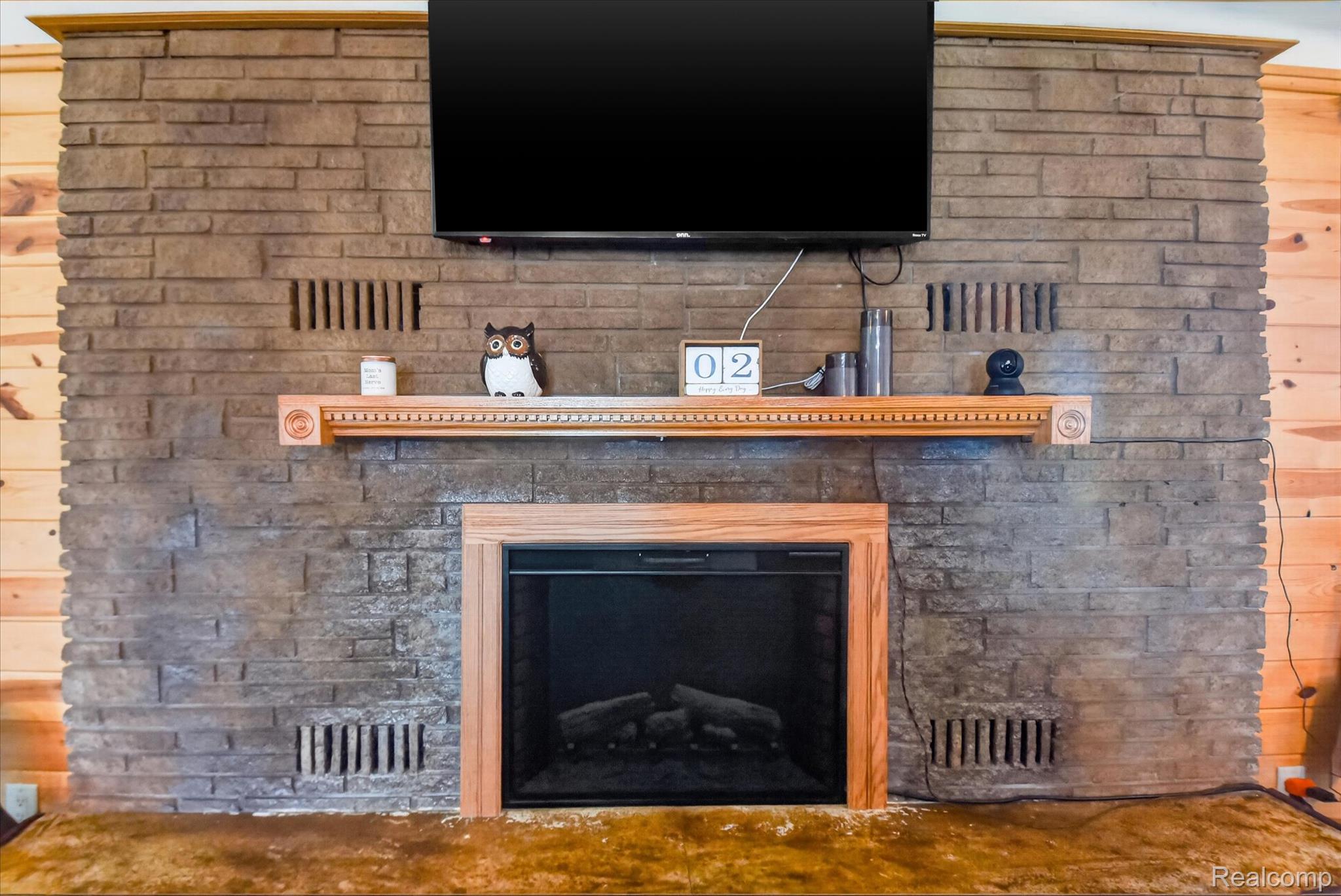 3949 West Burns Line Road Brown City, MI 48416 - Photo 12 of 70 Stone-faced fireplace featuring a wood mantel with decorative trim and a wood-framed insert