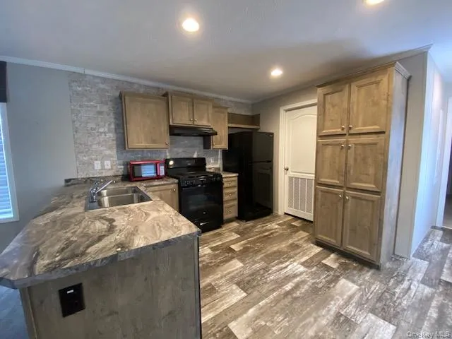 a kitchen with granite countertop a refrigerator stove and sink