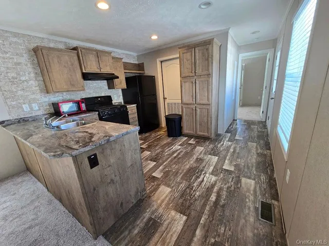 a kitchen with granite countertop a sink stove and refrigerator