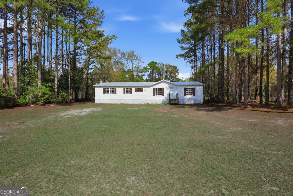 196 Barn Rd Circle Jesup, GA 31545 - Photo 1 of 31 a view of a house with a yard and tree s