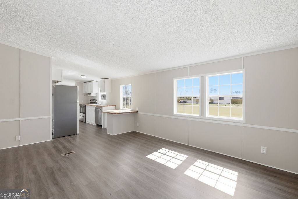 196 Barn Rd Circle Jesup, GA 31545 - Photo 12 of 31 a view of a kitchen with wooden floor and windows