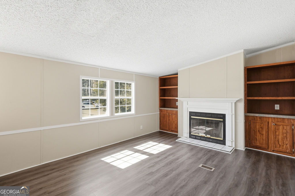 196 Barn Rd Circle Jesup, GA 31545 - Photo 13 of 31 a view of empty room with a fireplace and wooden floor