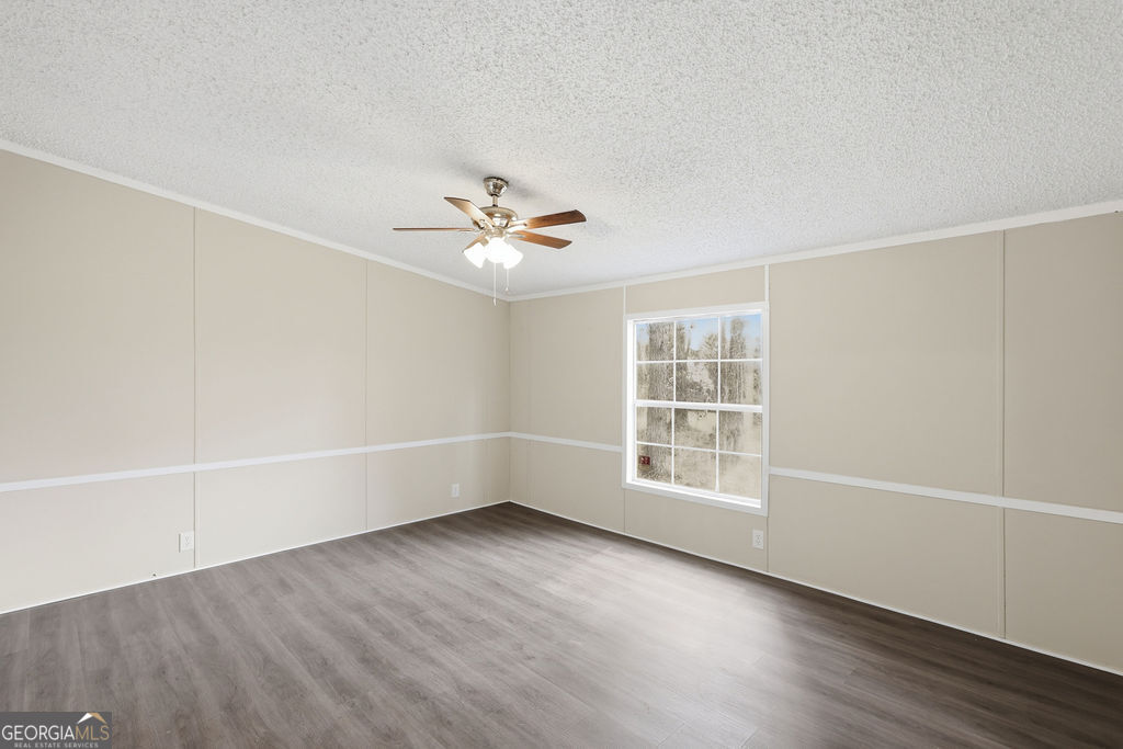 196 Barn Rd Circle Jesup, GA 31545 - Photo 14 of 31 wooden floor in an empty room with a window